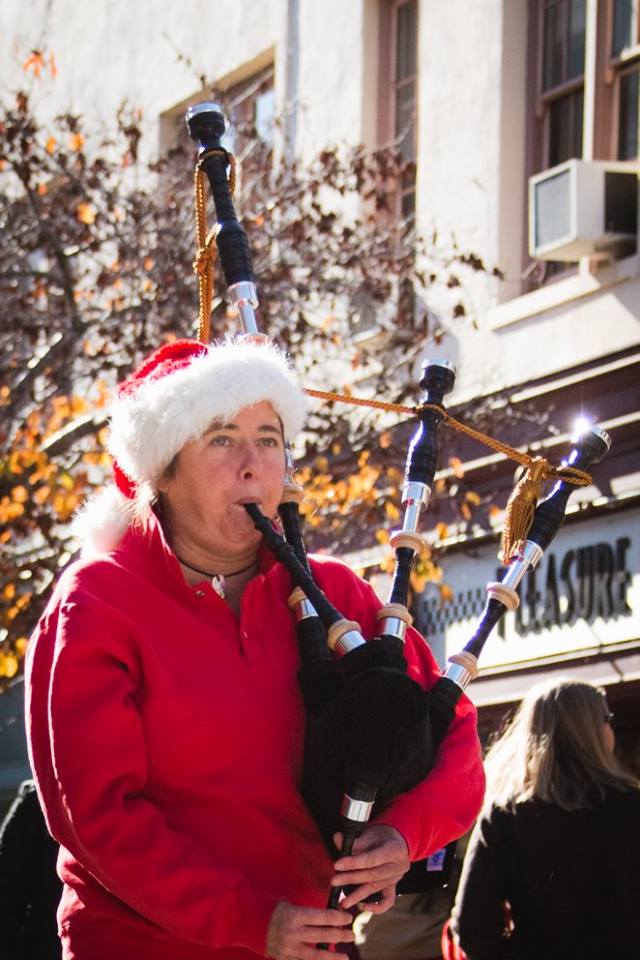 Elise playing Christmas songs on Great Highland Bagpipes, in the downtown Santa Cruz Christmas Parade.