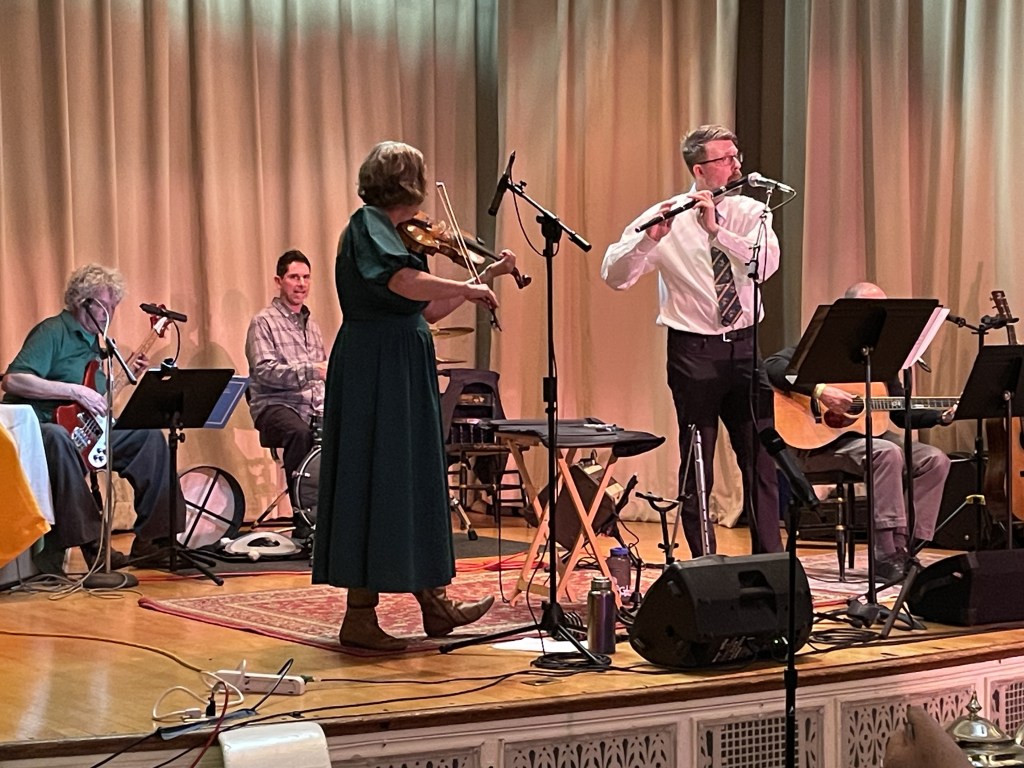 Elise MacGregor Ferrell plays fiddle onstage with flutist Aaron Clegg and other members of Charmas. 